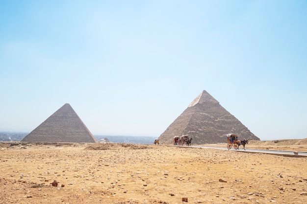 May 18, 2021. Giza, Cairo, Egypt. tourists in a horse-drawn carriage with the ancient pyramids of Giza on background