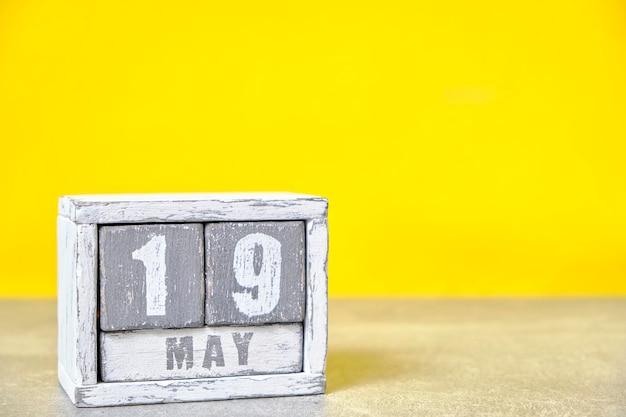 May 19 calendar made wooden cubes yellow backgroundWith an empty space for your text