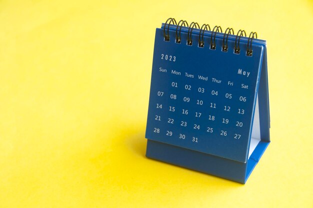 May 2023 blue desk calendar on yellow cover background with customizable space for text Copy space and calendar concept