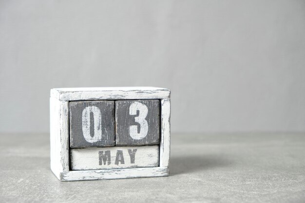 May 3 on calendar made wood painted in gray and white gray background