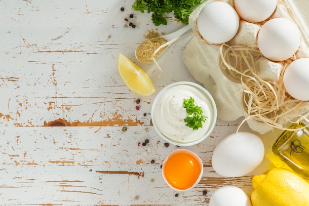 Mayonnaise sauce and ingredients on wood table