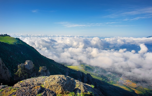 Meadow in the mountains over the clouds