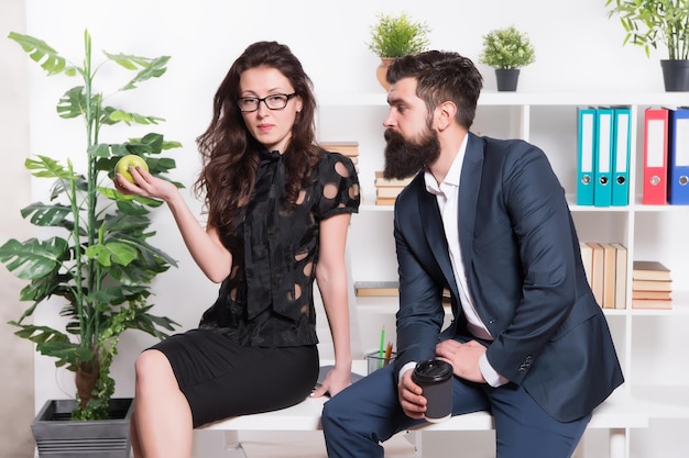 Meal break. Business couple enjoy office snack. Sensual girl and bearded man during work break. Snack break at workplace. Coffee break. Healthy eating. Vitamin nutrition. Office life. Working day.