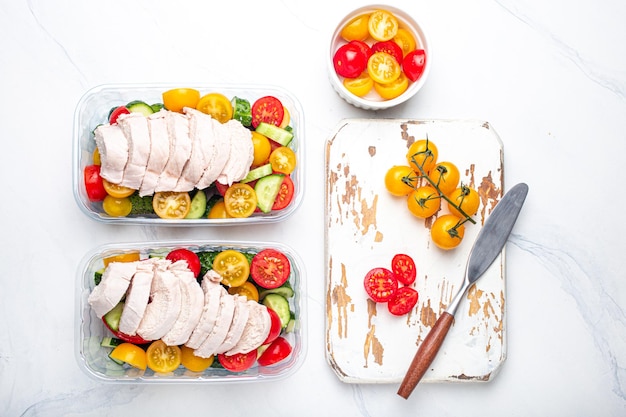 Meal prep lunch boxes containers with chicken and salad top view