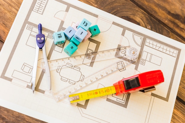 Measure tape, ruler, divider and math blocks on blueprint