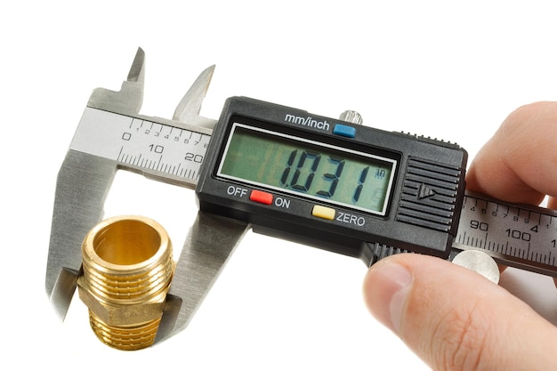 Measurement of plumbing fitting with digital caliper in masters hand