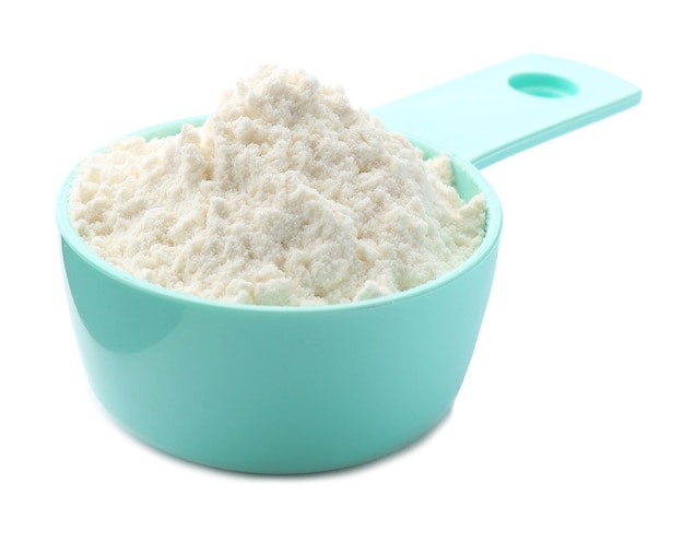 Measuring scoop with wheat flour on white background