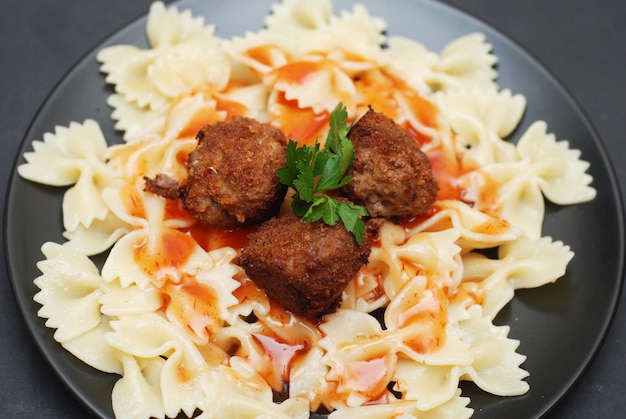 Meat balls with farfalle pasta, dark.