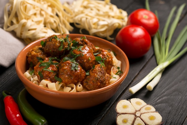 Meat balls with tomato sauce and pasta, close-up