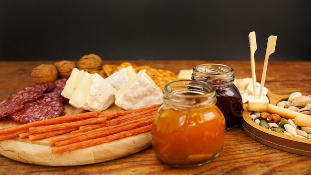 Meat and cheese plate for appetizers jars with jam and honey