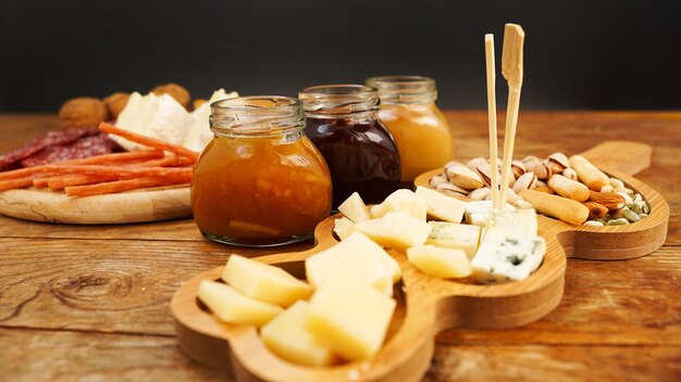 Meat and cheese plate for appetizers jars with jam and honey