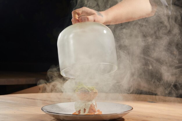 Meat under the cloche with smoke in the restaurant