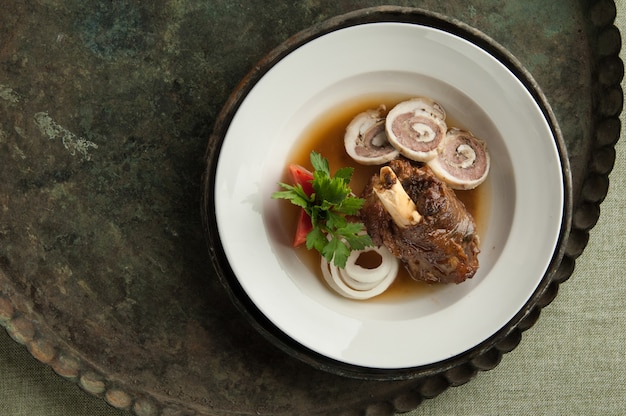 A meat dish with a bone on an old antique tray