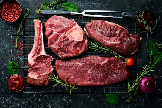 Meat. Fresh raw veal steaks and meat. Top view. Flat lay top view on black stone cutting table.