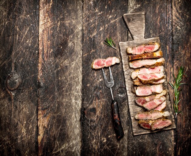 Meat grill. Grilled steak pork with spices and herbs .On the old wooden table.