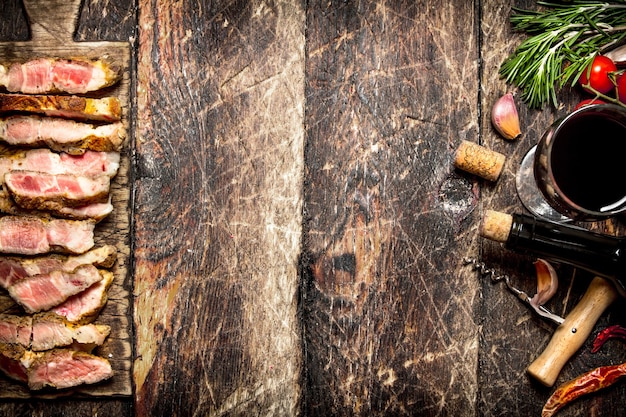 Meat grill. Pieces of pork grilled with spices and red wine on old wooden table.