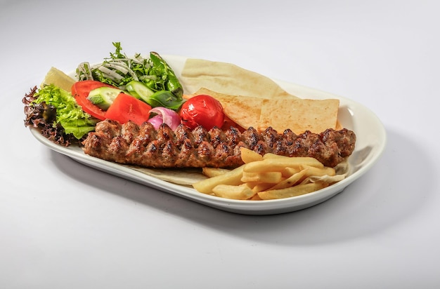 MEAT kebab platter with salad fries and pita bread served in dish side view of arab food