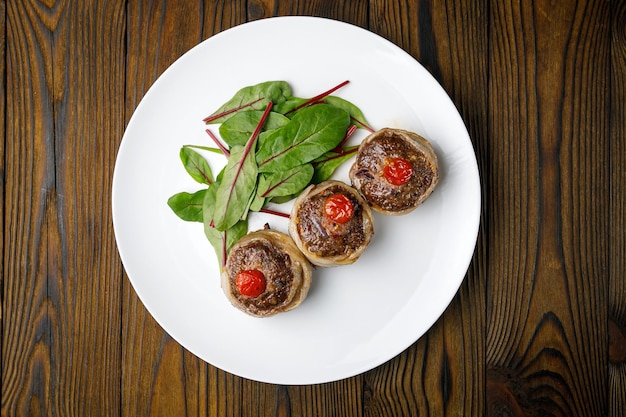 meat products on a white plate on a wooden table