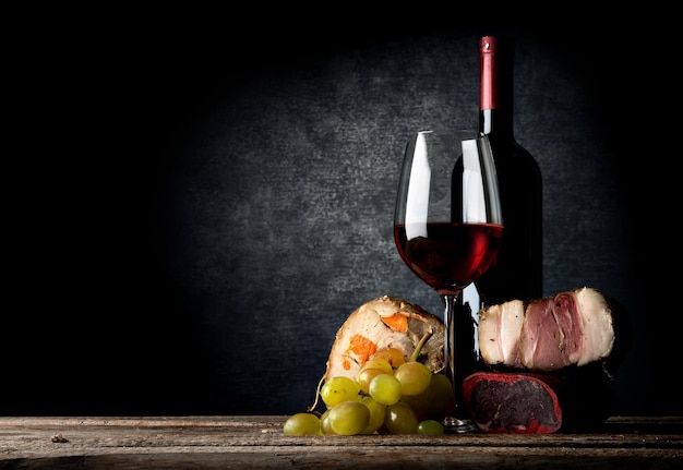 Meat and red wine on a wooden table