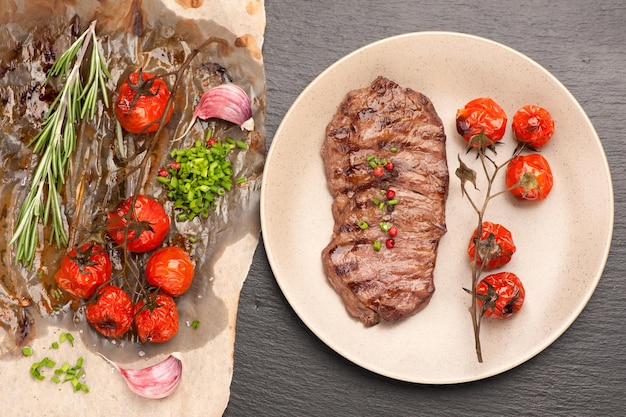 Meat Ribeye steak entrecote with roasted tomatoes and herbs