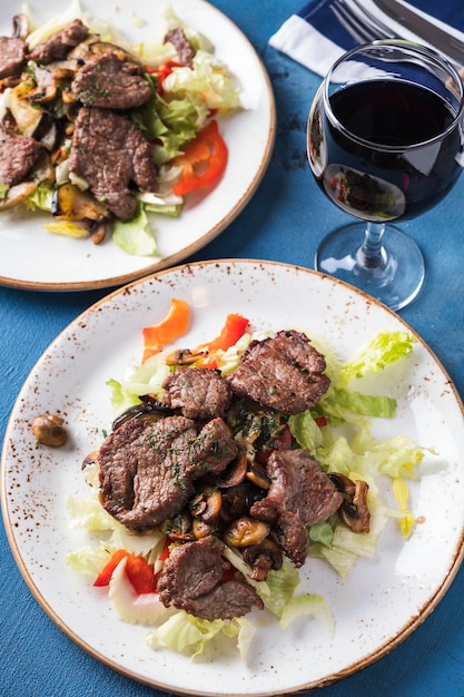 Meat salad with fresh vegetables on a plate Top view