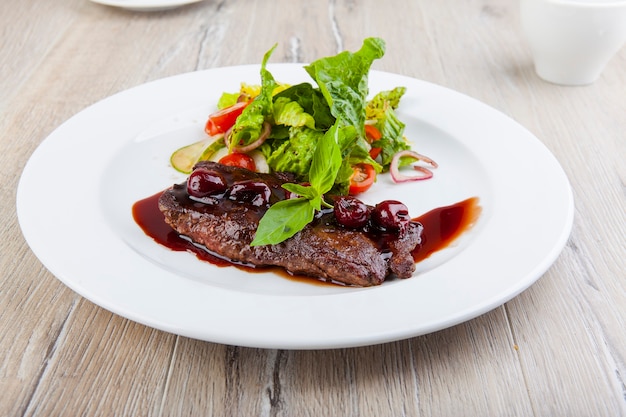 meat schnitzel with cherry sauce and vegetables