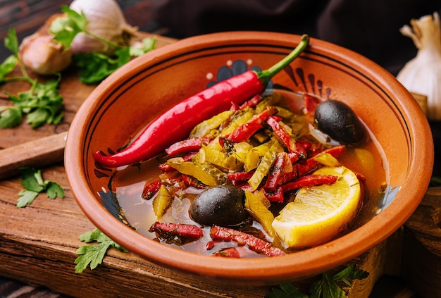 Meat Solyanka soup on a wooden board