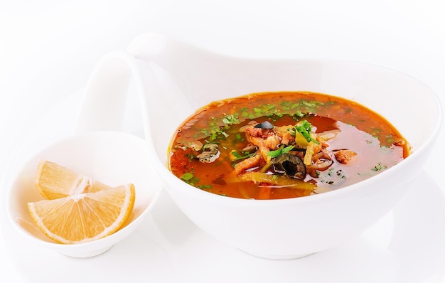 Meat soup Solyanka in bowl isolated on white background