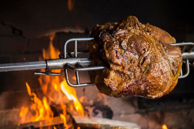 Meat on a spit in the oven Grilled pork in open flame