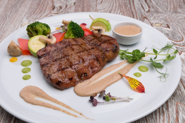 Meat steak on a plate with vegetables