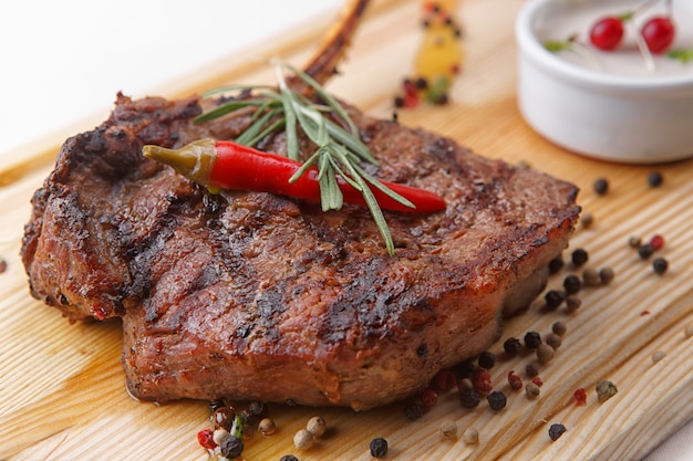 Meat steak with sauce on a wooden board