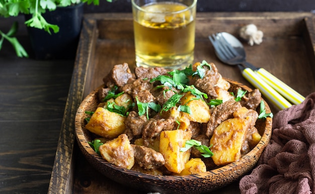 Meat stew with potatoes and parsley in wooden dish. Traditional Portuguese meat stew.