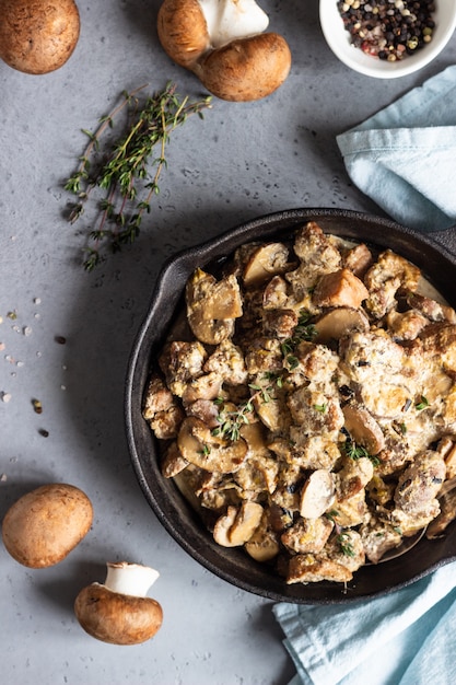 Meat stewed with mushroom and thyme in a cast iron pan