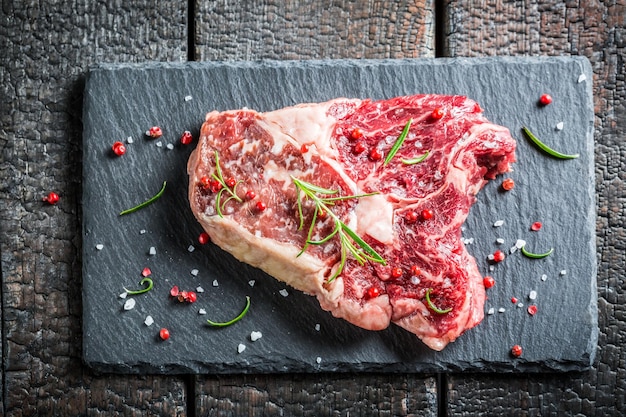 Meat with rosemary and pepper on a stone plate