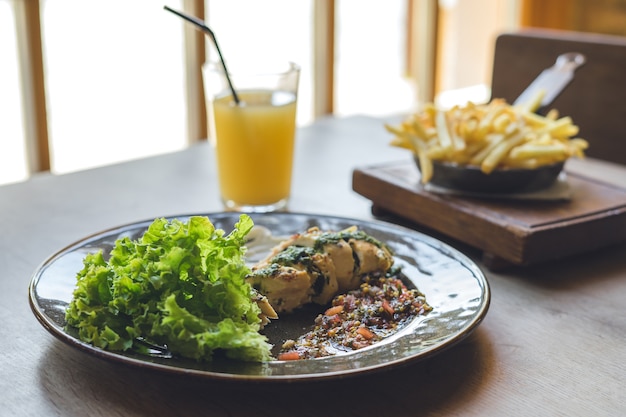 Meat with sauce and salad on wooden table