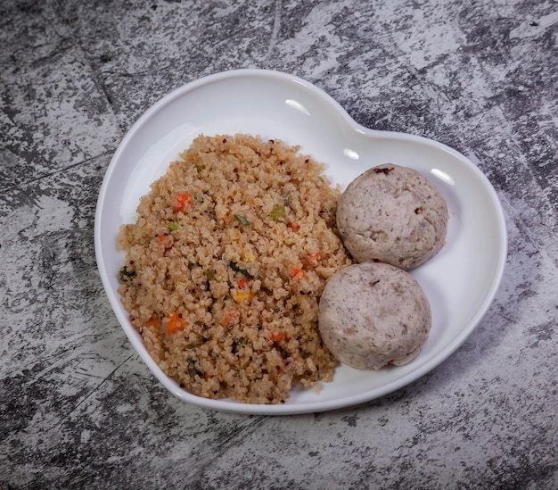 Meatballs of chicken fillet with garnished quinoa with vegetables on textured background