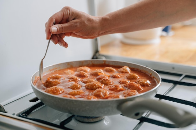 Meatballs cooking process in a pan at home Beef chicken and pork meat food recipe in tomato sauce