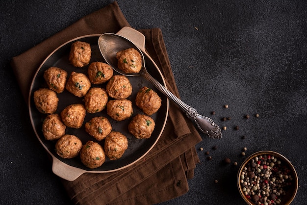 Meatballs in a frying pan on dark background