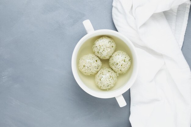 Meatballs of Turkey or chicken with spinach in clear broth, top view. Healthy dieting food.