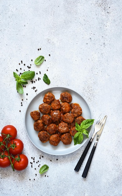 Meatballs with tomato sauce and basil in a plate top view with space for text