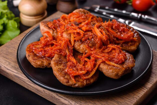 Meatballs with tomato sauce and herbs on the black plate