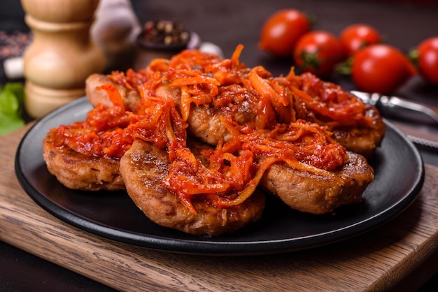 Meatballs with tomato sauce and herbs on the black plate