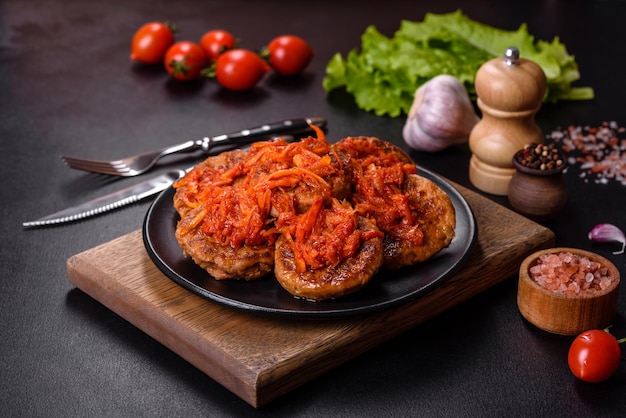 Meatballs with tomato sauce and herbs on the black plate