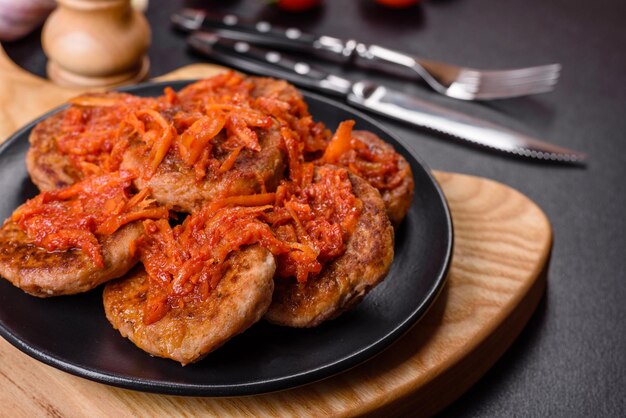 Meatballs with tomato sauce and herbs on the black plate