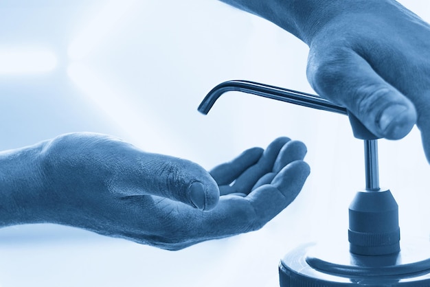 Mechanic applying washing soap to clean dirty hands after work