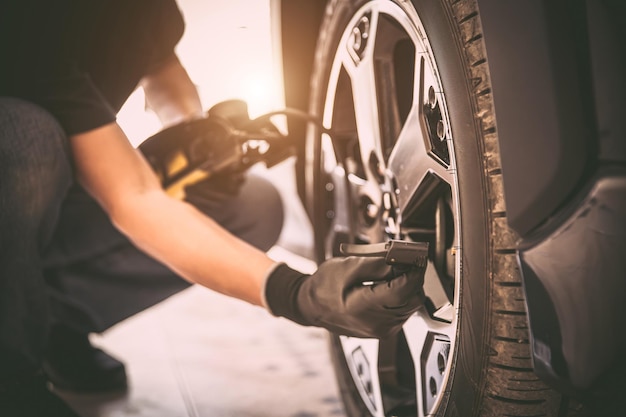 Mechanic checking air pressure and inflating car tires