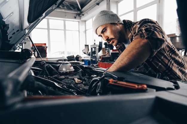 Mechanic examining car in auto car repair service center