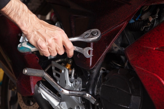 Mechanic fixing a motorcycle in the garage