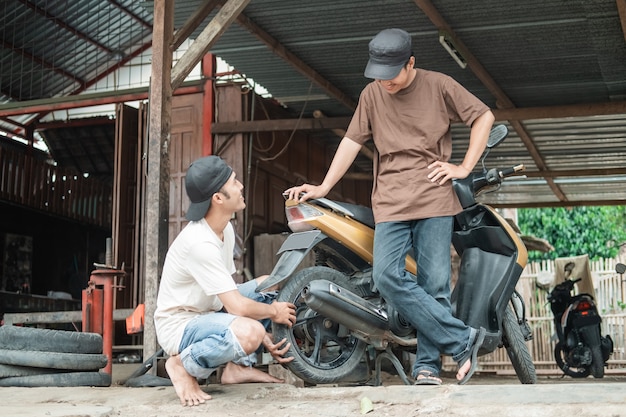 mechanic helping a customer to fix scooter motorbike