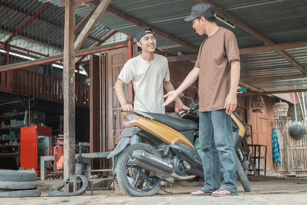 mechanic helping a customer to fix scooter motorbike